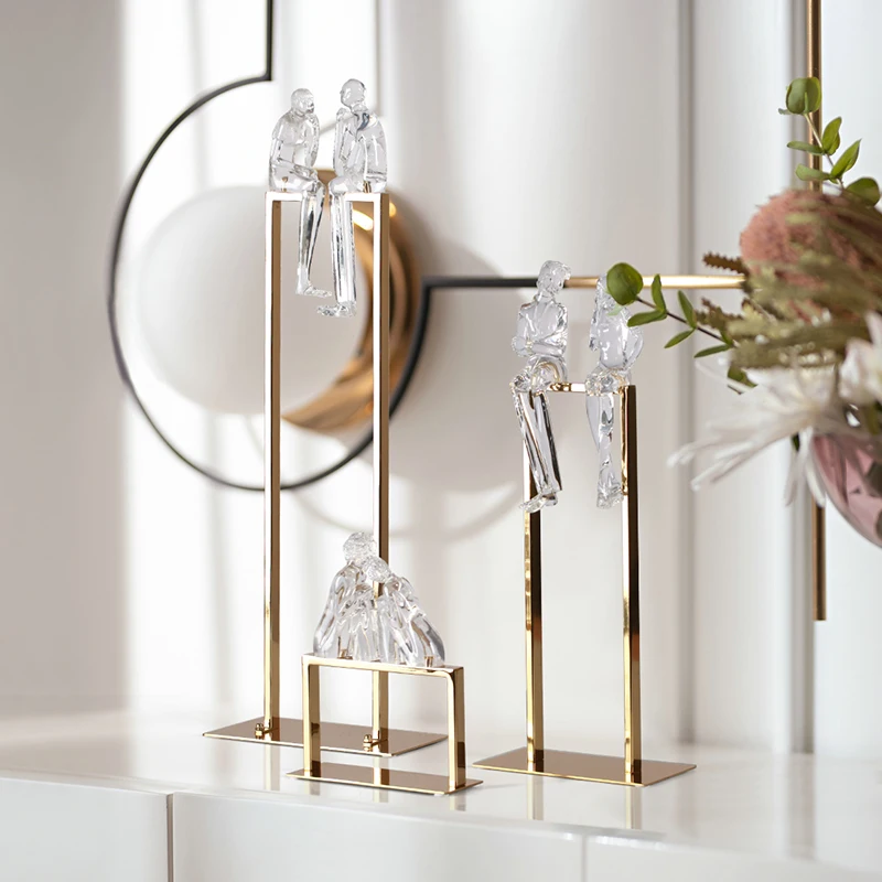 Творческая пара прозрачных абстрактных фигурок из смолы сидя на металлической