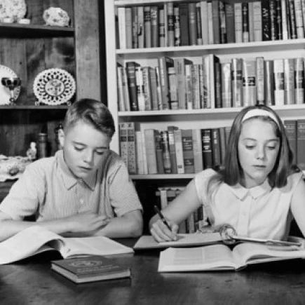 Для мальчиков подростков и девочек обучающихся за столом с плакатом