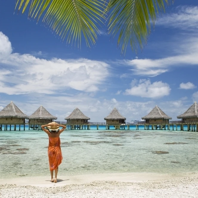 Французская Полинезия Tuamotu Islands Rangiroa Atoll Woman на пляже возле роскошного курорта.
