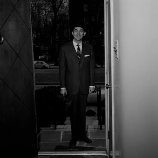 Человек носить костюм стоя в дверях плакат-наклейка для дома печати (18x24) | Дом и