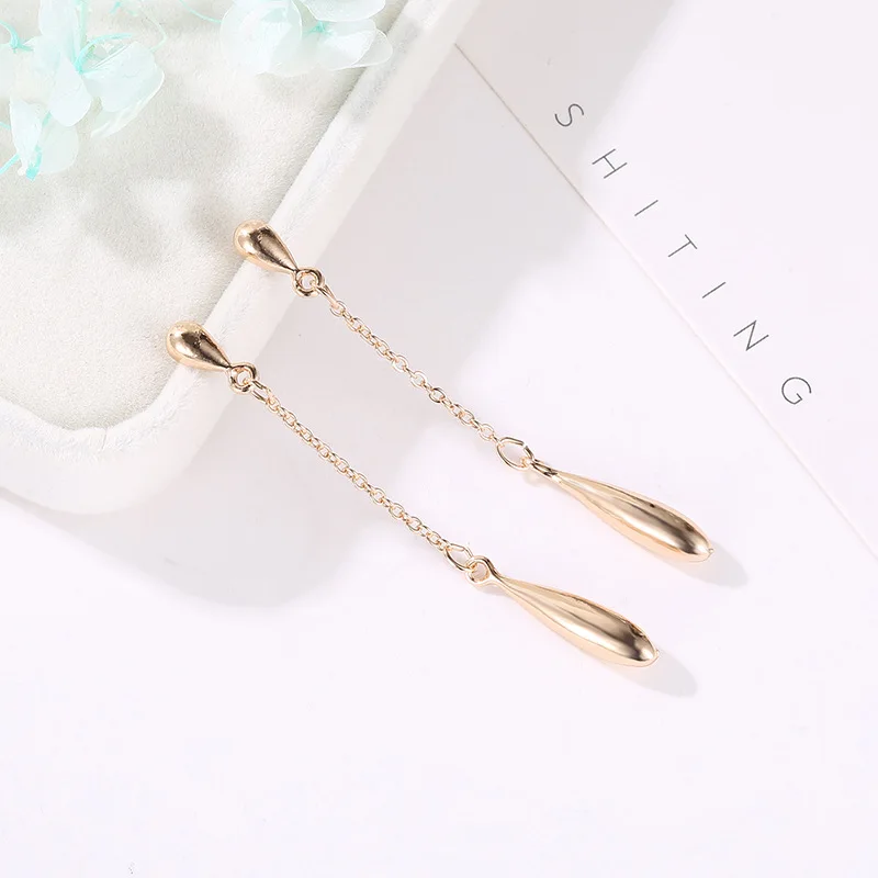 Простые висячие серьги золотистого цвета с кисточками в виде капель воды для