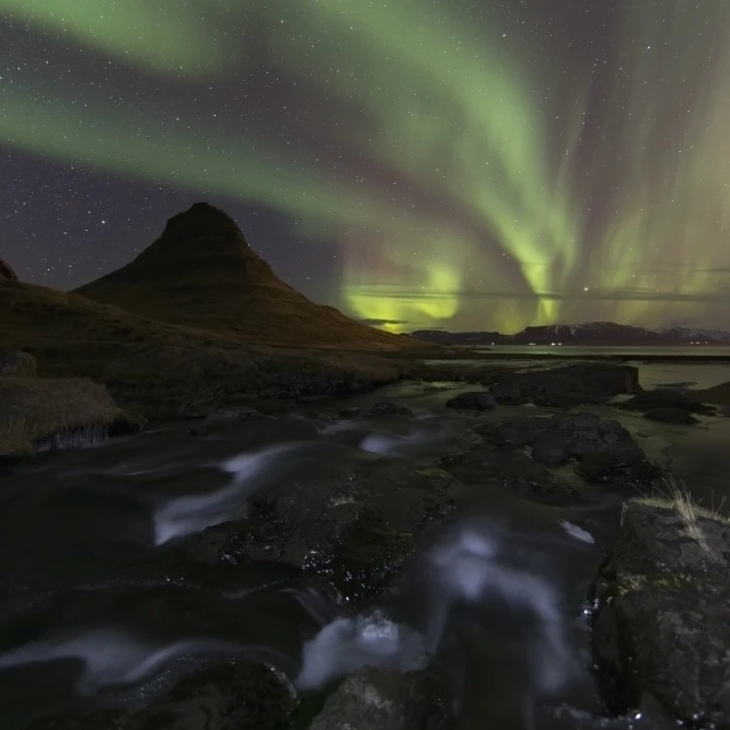 Северное сияние над киркюфеллом в городе грундарфьортхур полуостров