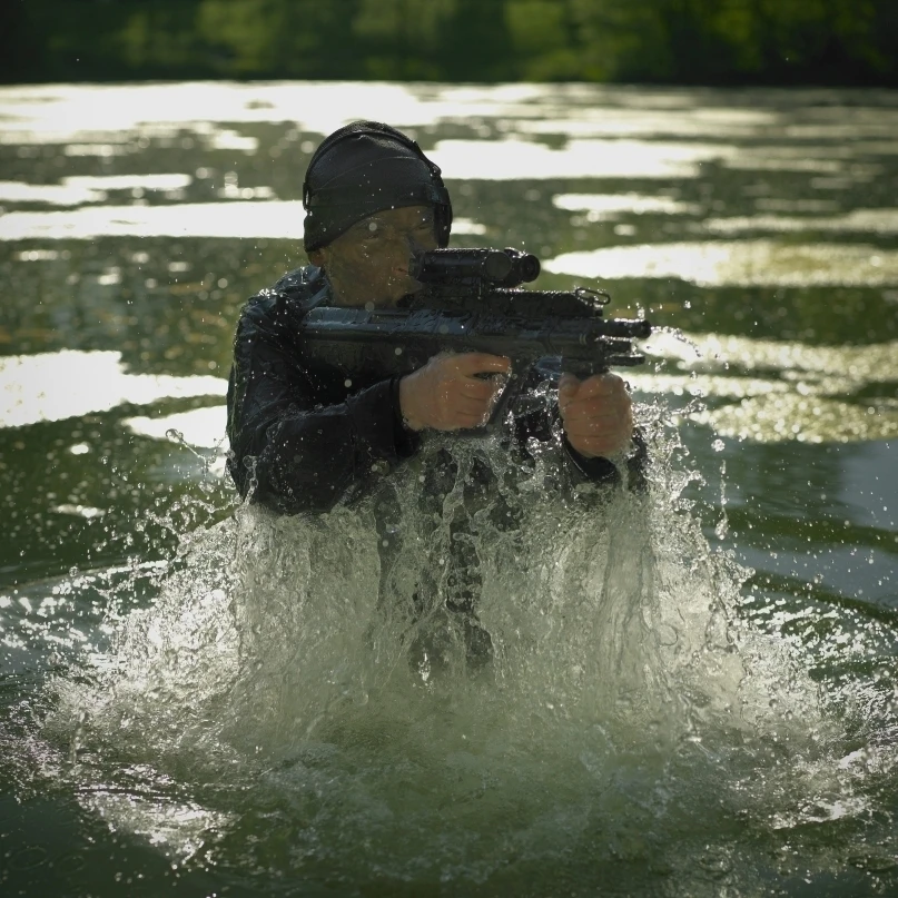 Солдат сил специальных операций выходит из воды вооруженный Steyr AUG assault rifle Poster Print