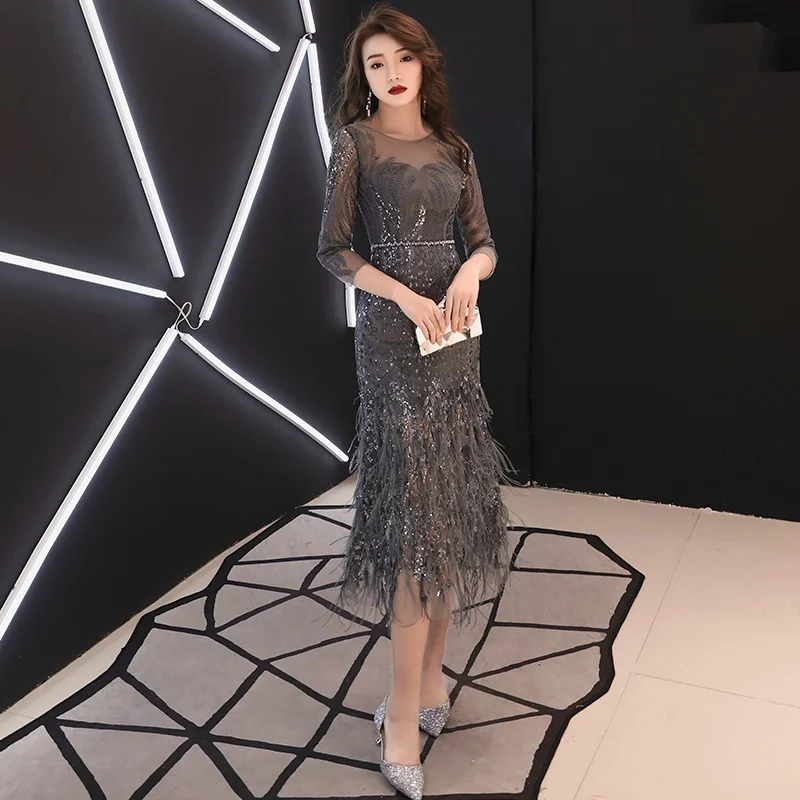 Женское вечернее платье с перьями серое приталенное коктейльное копчиком модель