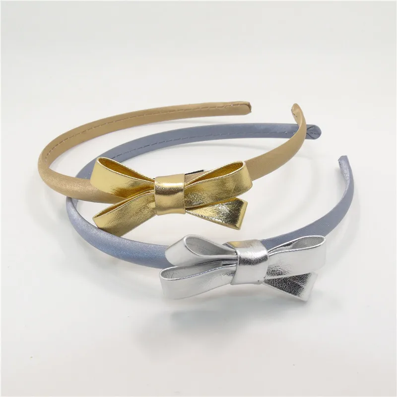 Повязка на голову из искусственной кожи с бантом золотистая/серебристая |