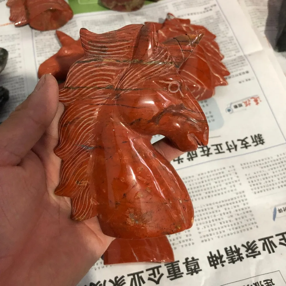 

A natural ruby sculpture of a horseshoe unicorn with a quartz crystal skull