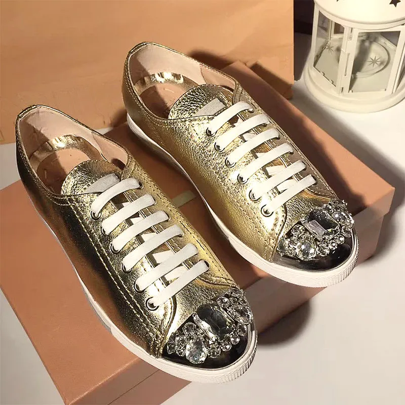Женские кроссовки со стразами украшенные на плоской подошве шнуровкой