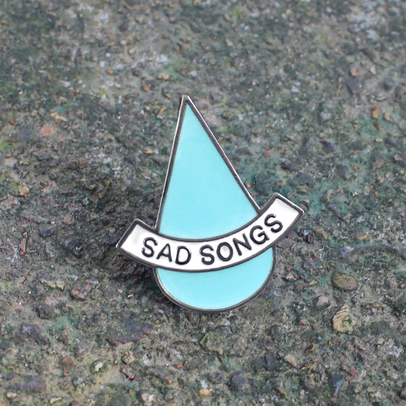 La spilla a forma di goccia blu &quotSAD SNOGS&quot rappresenta uno stato dɺnimo triste tristezza non convenzionale adatta agli amanti |