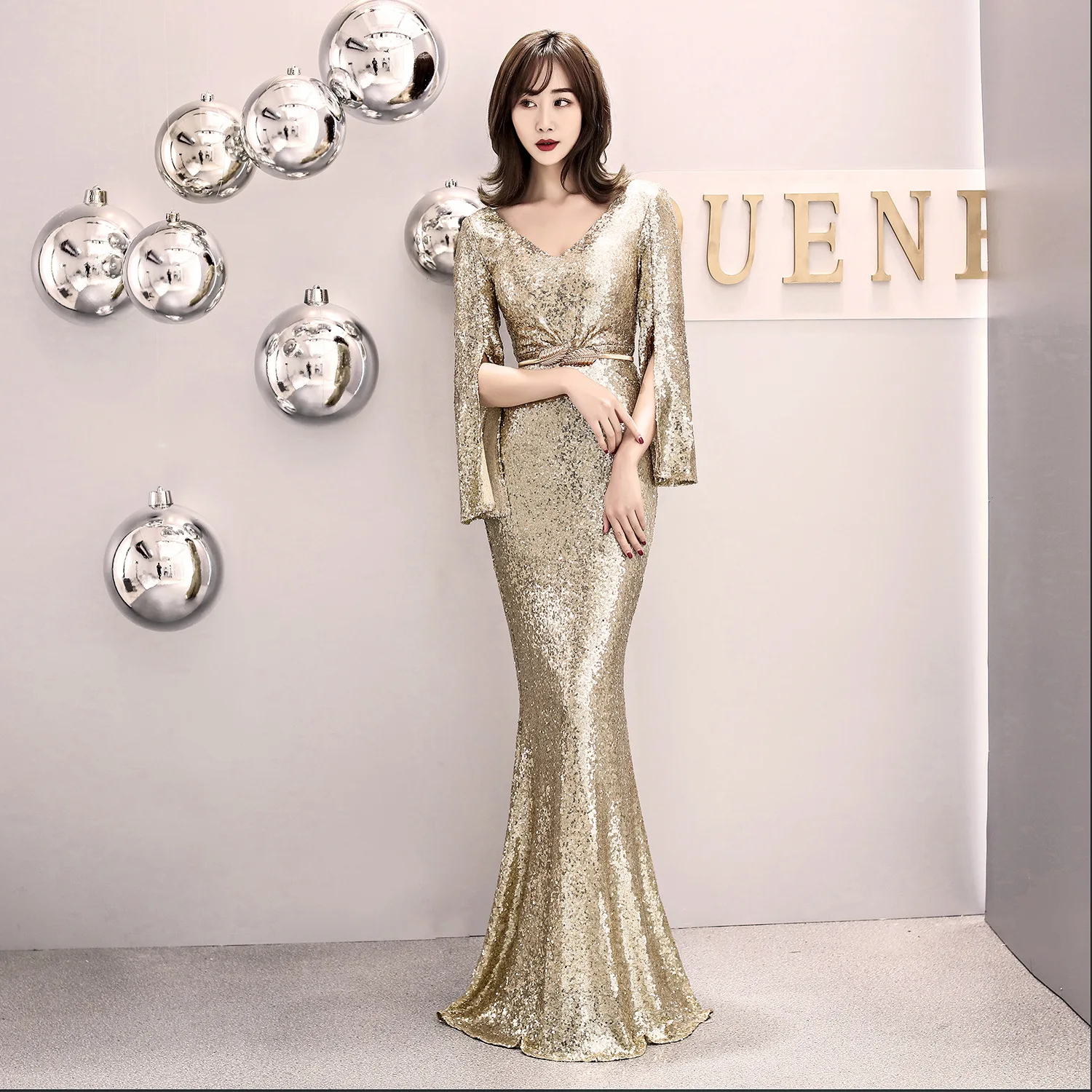 Золотое расшитое блестками платье с глубоким v образным вырезом разрезным