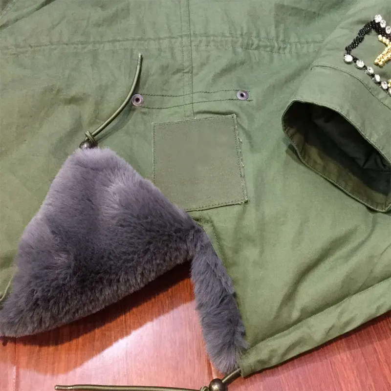 Модное серое зимнее пальто с искусственным мехом украшенное бисером капюшоном