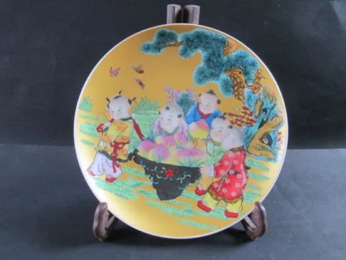

Красивая старинная тарелка из китайского фарфора, нарисованная пятью милыми мальчиками, носит персики на день рождения