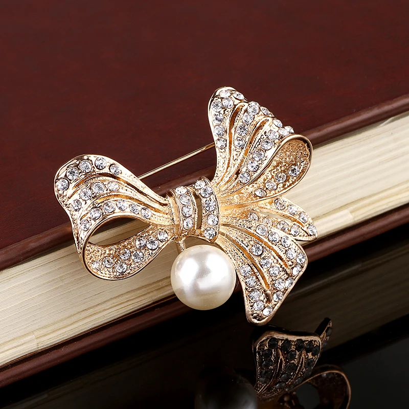 Женская Брошь золотого цвета со стразами и жемчужным бантом брошь с кристаллами