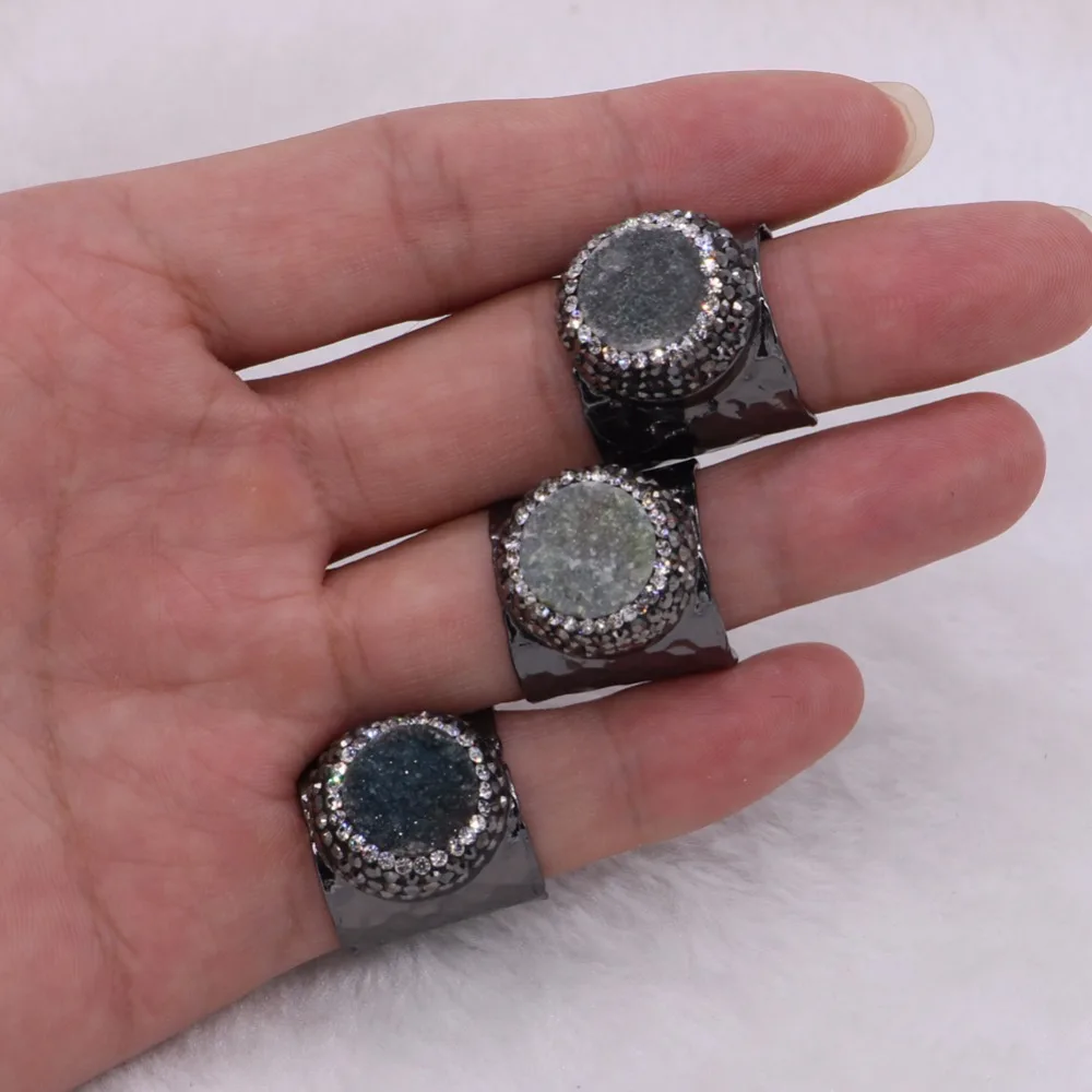 Черные металлические кольца покрытые пистолетом проложить горный хрусталь и