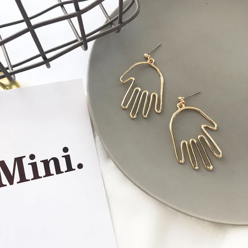 Женские серьги подвески золотистого цвета эффектные в форме лица или руки