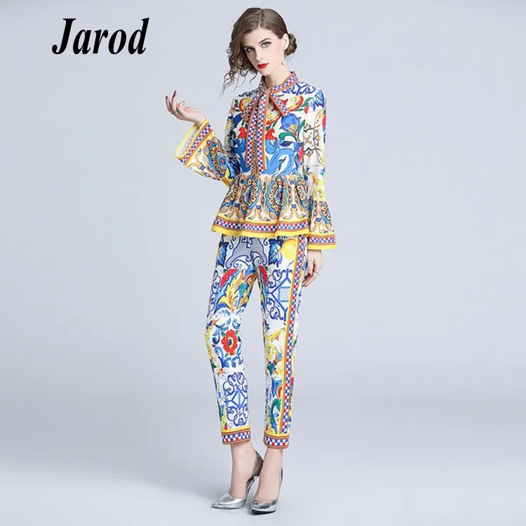 

Женский модельный дизайнерский брючный костюм, блузка с расклешенным рукавом и цветочным принтом и бантом и брюки-карандаш, осень 2018