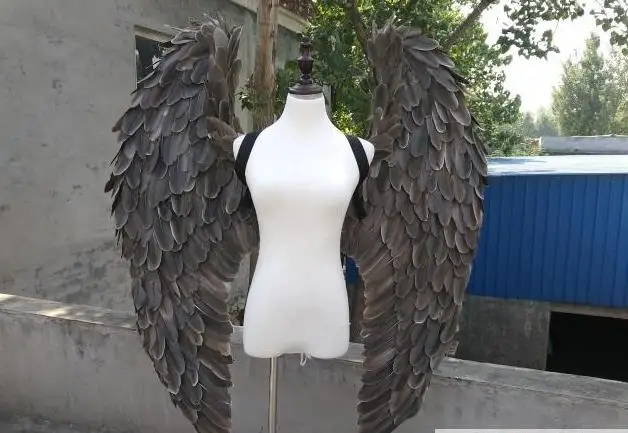 Черные крылья ангела демона, большие перья, модель, подиум, реквизиты, косплей, студийная фотография.