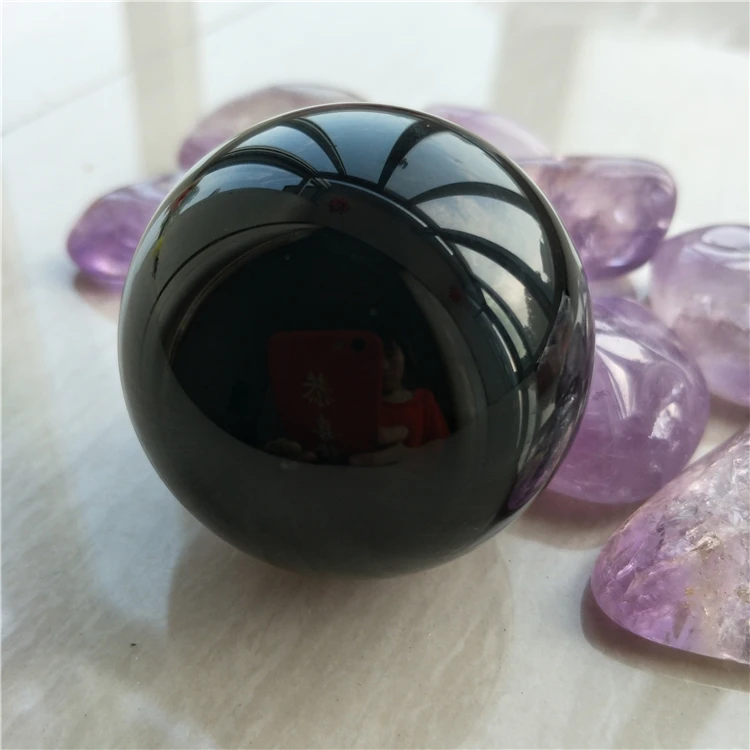 Большая черная Обсидиановая Сфера фотолампа держит отрицательную энергию