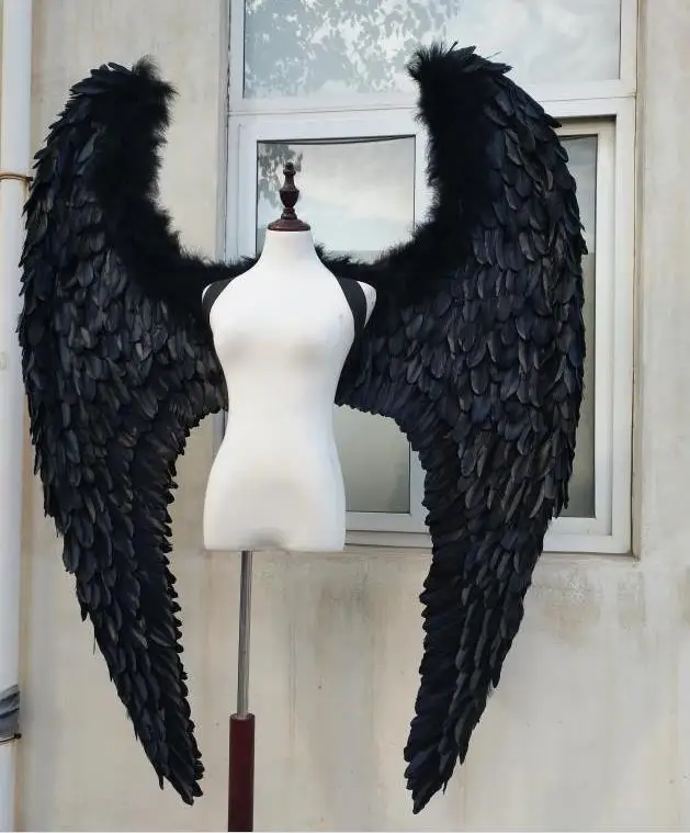 Черные крылья ангела демона, большие перья, модель, подиум, реквизиты, косплей, студийная фотография.