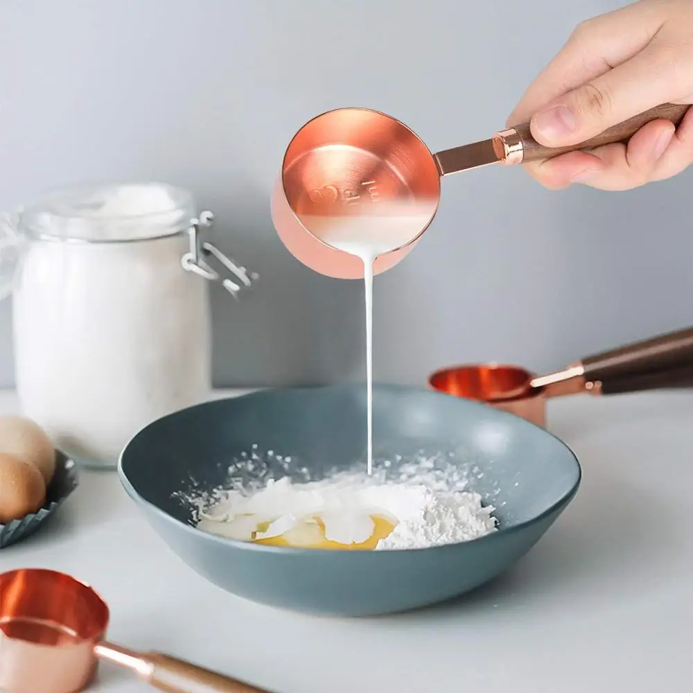 Набор мерных стаканчиков из розового золота с длинной деревянной ручкой