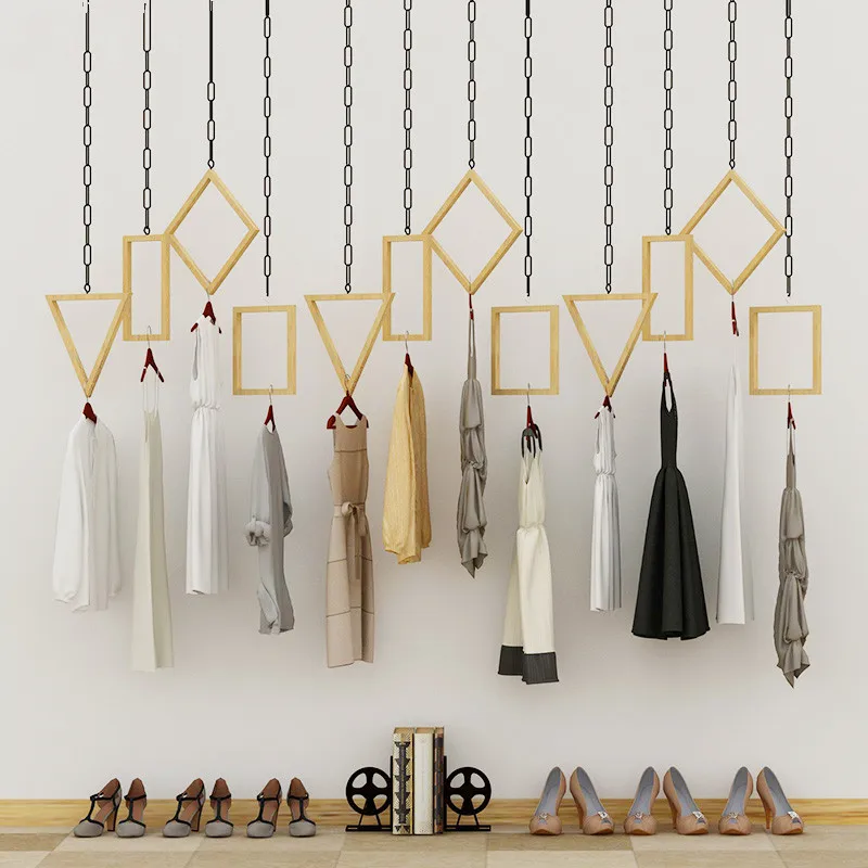 Многофункциональная вешалка висящая на стене витрины в магазине одежды|Крючки и