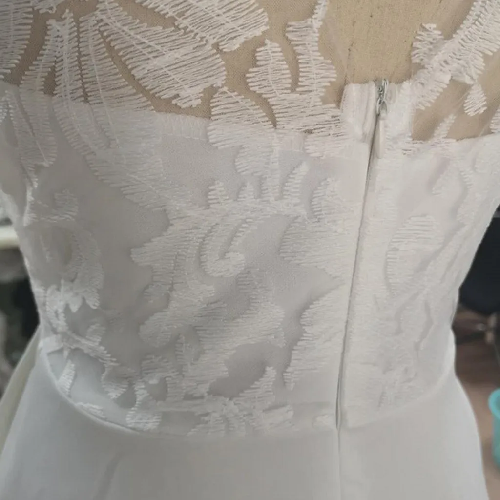 Женское платье средней длины белое без рукавов с треугольным вырезом