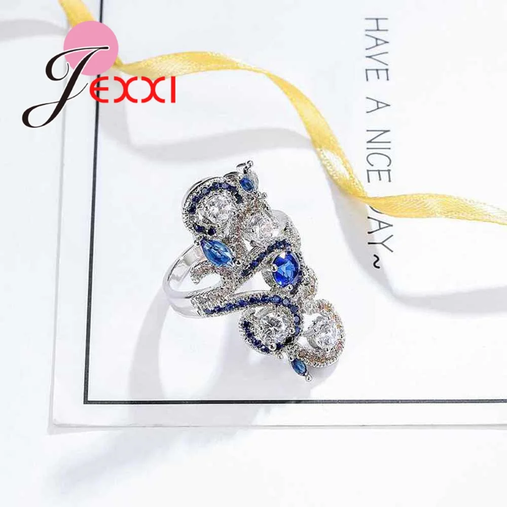 Кольцо с цветком преувеличенного цвета украшенное синим и белым кубическим