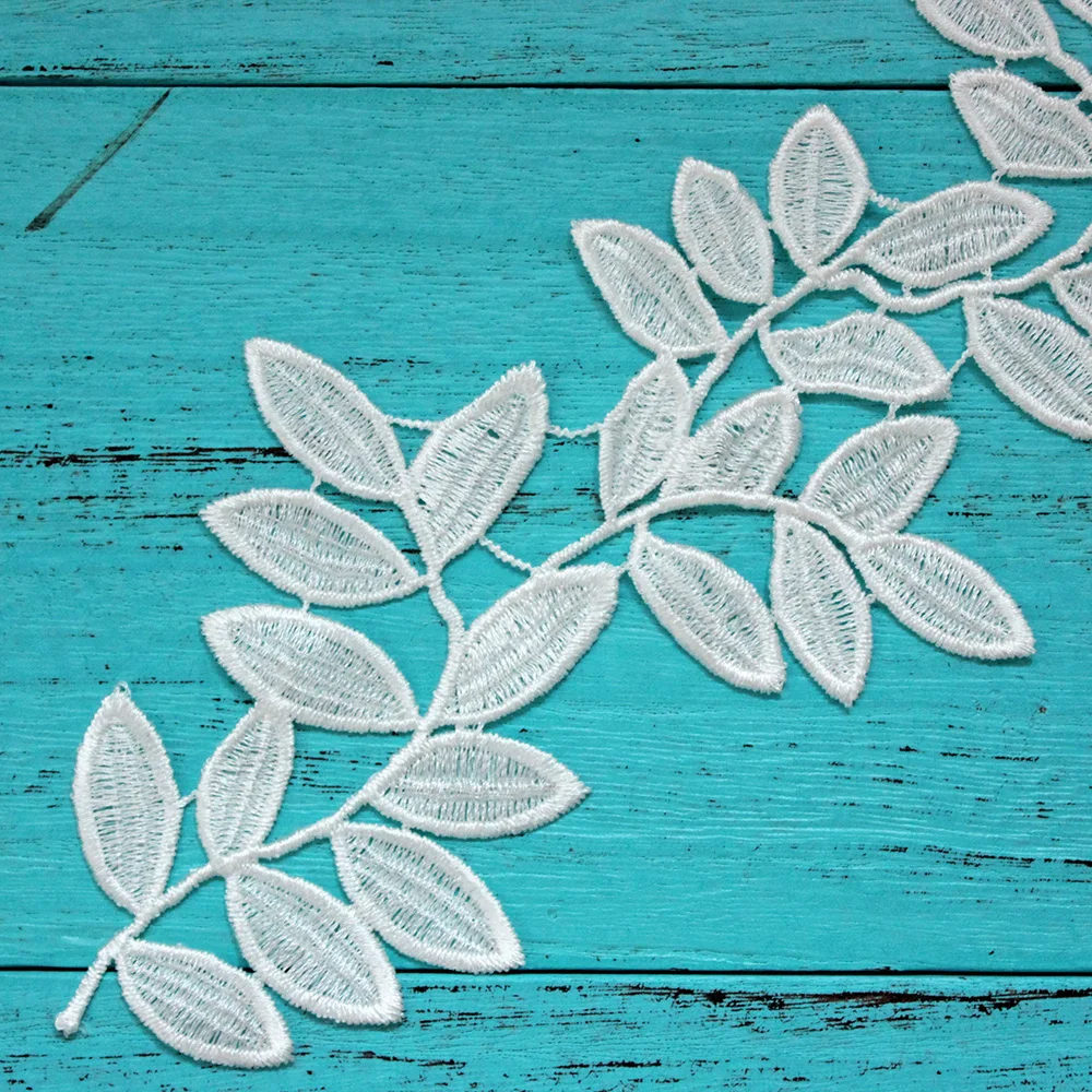 Кружевная аппликация в виде больших белых цветов и листьев вышитая кружевная
