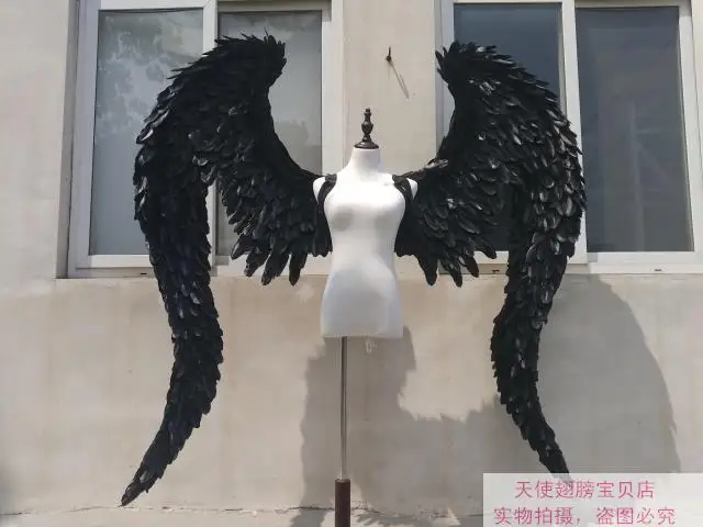 Черные крылья ангела демона, большие перья, модель, подиум, реквизиты, косплей, студийная фотография.
