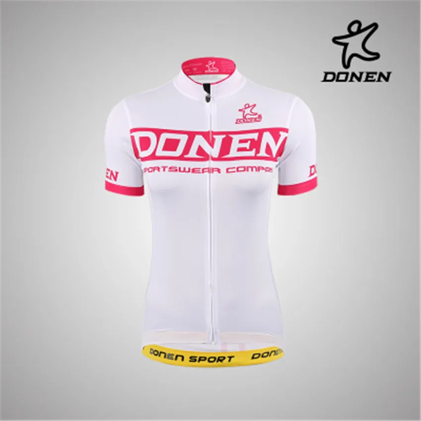 Дамский велосипедный комплект DONEN Cycling в розовой короткорукавной майке команды, с краткими шортами со шлейфами и вкладышами под гонку на велосипеде.