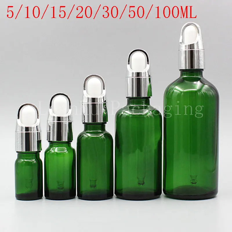 Зеленая стеклянная бутылка с серебряной корзиной для цветов пустой