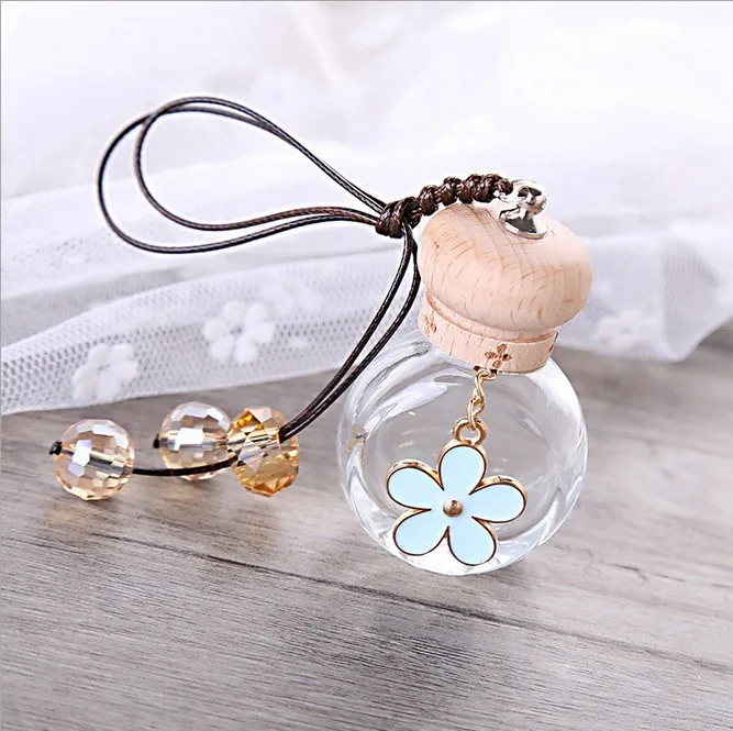 Круглая прозрачная стеклянная бутылка с ароматом и подвеской в виде цветов