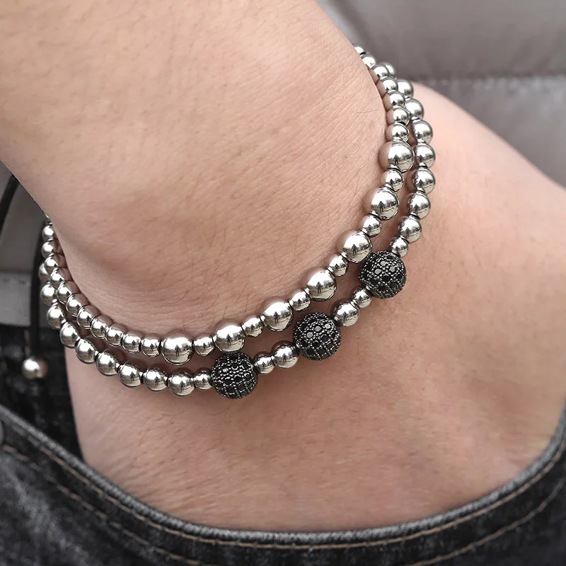 Набор из 2-х черных браслетов на мужскую руку с кубическим цирконием, бусинами из нержавеющей стали и растяжкой для удобства ношения, серебристого цвета. Товар доступен для дропшиппинга. (Перевод может незначительно отличаться в зависимости от контекста.)