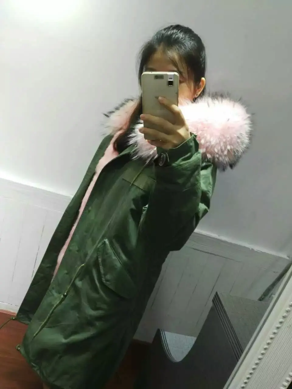 Женская длинная парка с капюшоном и воротником из меха енота серо зеленая