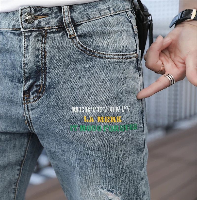 

Trendy men's spring new pierced jeans Korean slim legged pants personalized printing hot casual pants