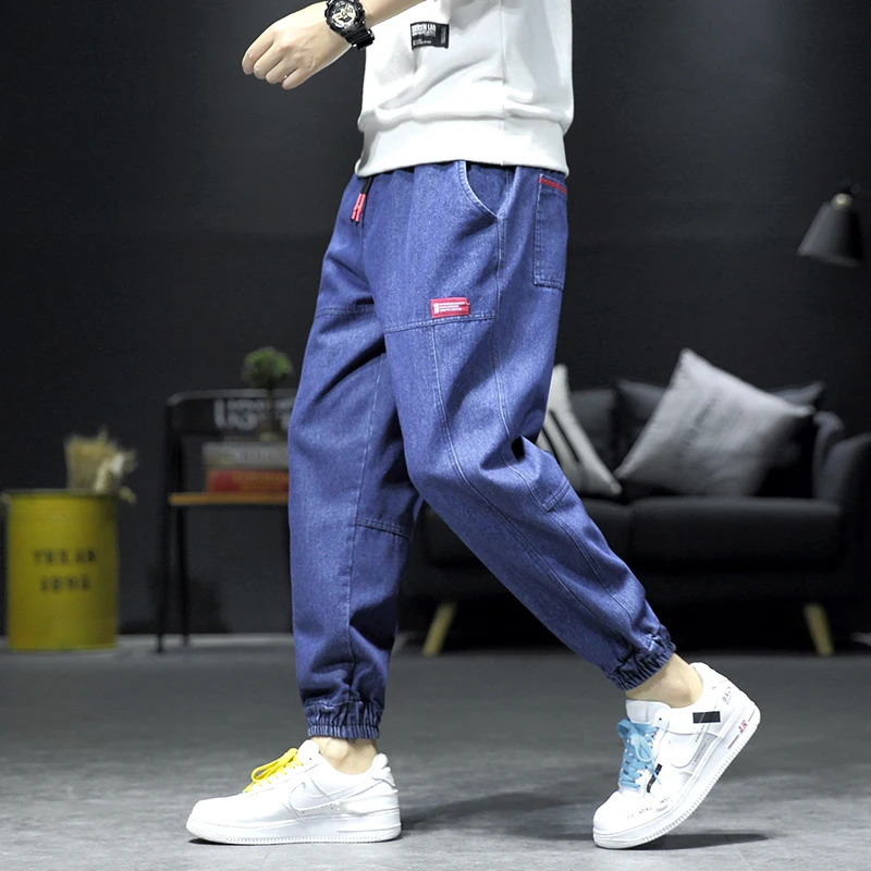 Мужские синие джинсы на диване с черной стенкой штаны завязками лодыжке мужские