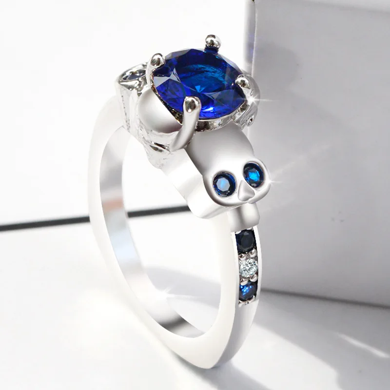 

Женское кольцо в стиле панк с голубым кристаллом и черепом из циркония