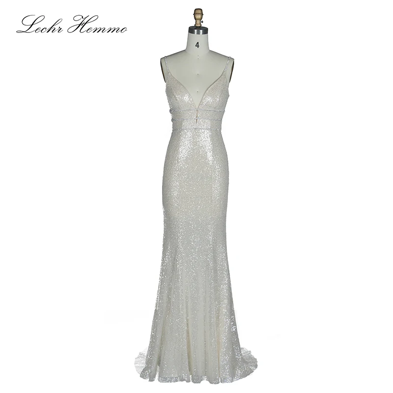 Женское вечернее платье белого цвета с глубоким v образным вырезом и блестками