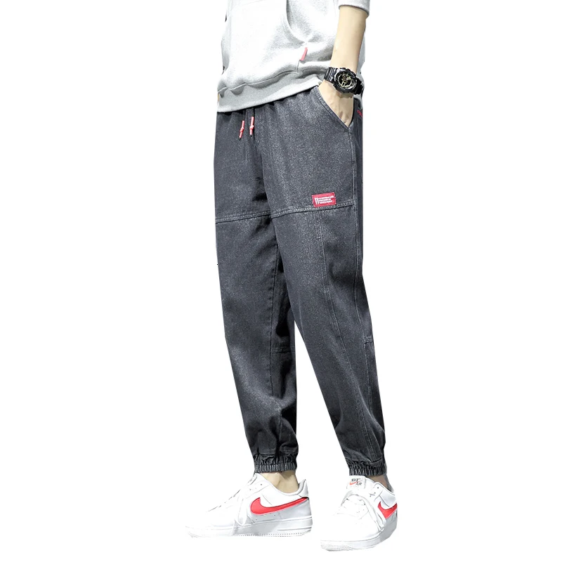 Мужские синие джинсы на диване с черной стенкой штаны завязками лодыжке мужские