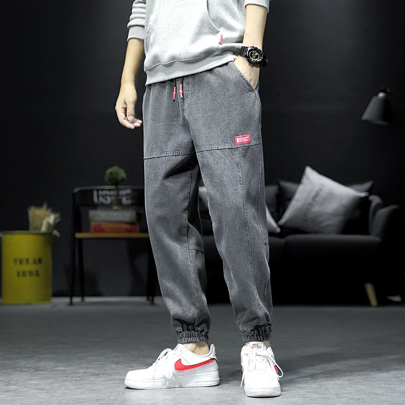 Мужские синие джинсы на диване с черной стенкой штаны завязками лодыжке мужские