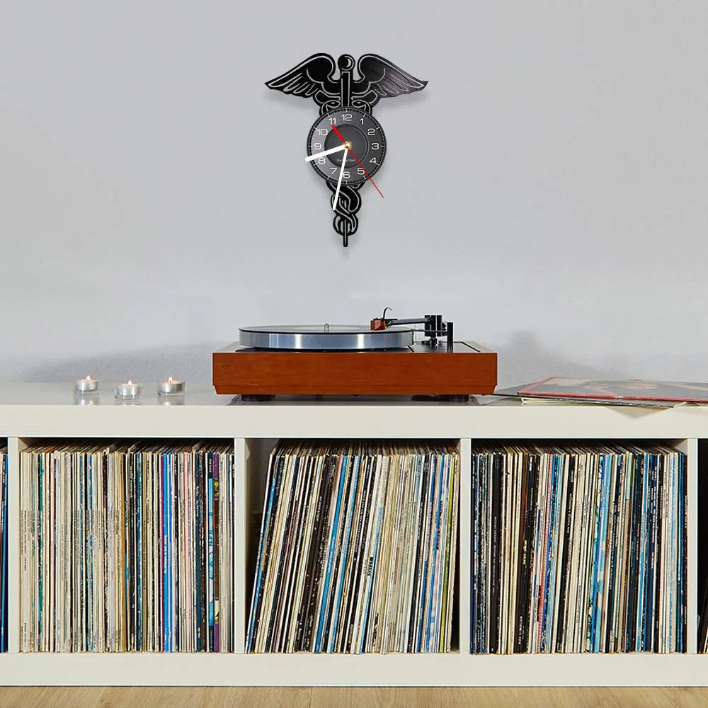 Часы настенные виниловые с изображением крыльев змеи и пластинки в медицинской