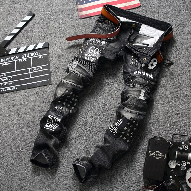 

ABOORUN Mens Punk Rivet Patchwork Jeans Ripped Pleated Biker Jeans Letter Printed Denim Pants for Male R2788