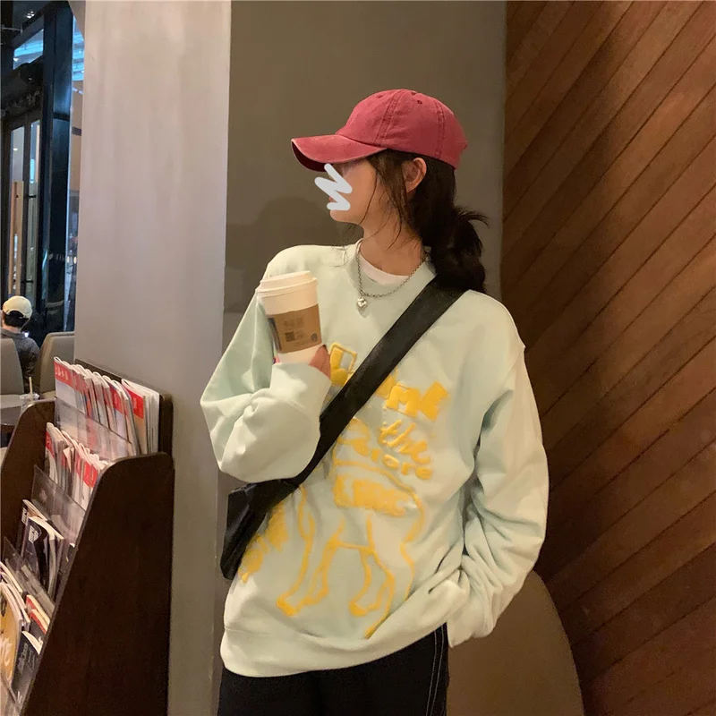 

Женский осенний свитер светло-зеленого цвета с принтом в виде потертостей