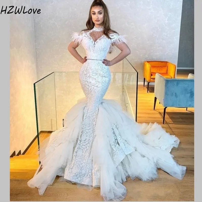 Белое свадебное платье с перьями юбкой годе высоким воротником и рукавами