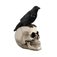 halloween raven on skull decoration gothic crow on skull statue bird perching on skeleton figurine ossuary sculpture