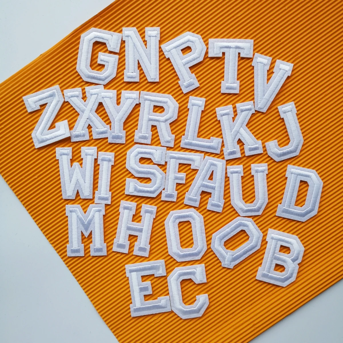 Компьютерной вышивки нашитая буква с вышитыми белыми Алфавит значки надписями в