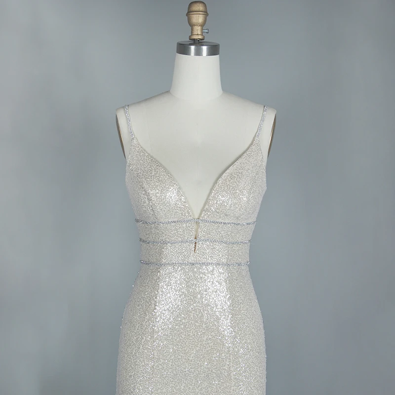 Женское вечернее платье белого цвета с глубоким v образным вырезом и блестками