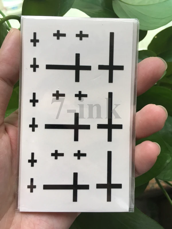 Татуировка переводная ненастоящая маленькая перекрестная за ухом на пальце