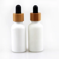 wholesale custom cosmetic matte white round dropper bottles with bamboo lid essential oil perfume skin care container packaging