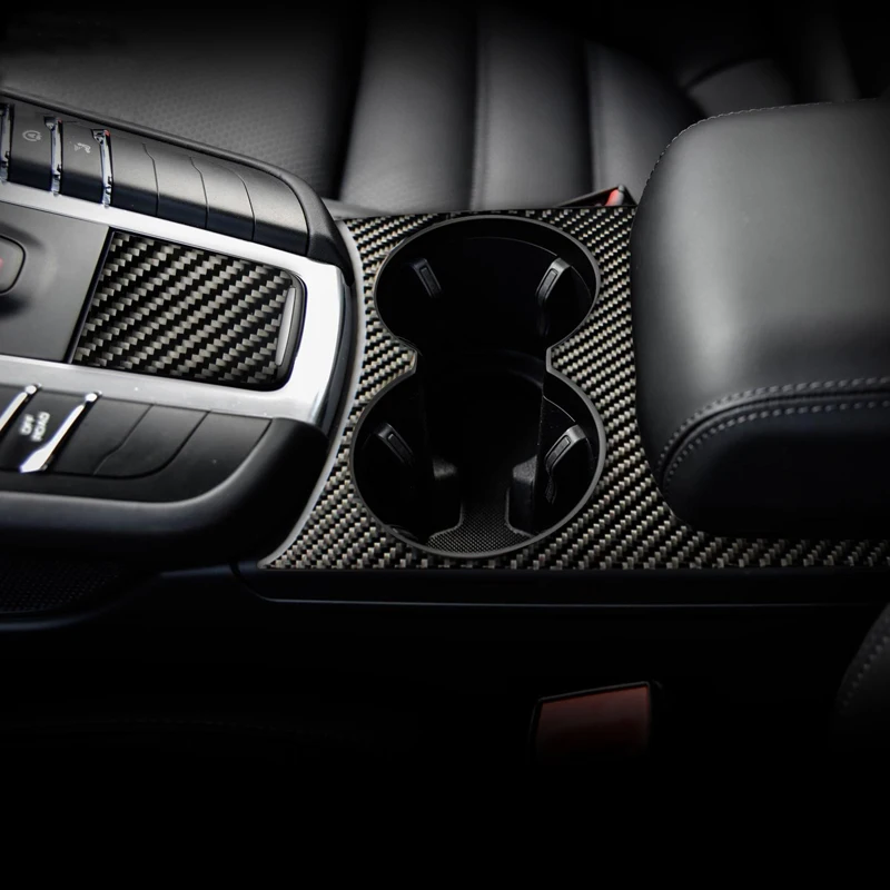 Аксессуары для Porsche Macan: панель управления, ручка переключения передач, крышка подстаканника и декоративная наклейка из карбонового волокна.