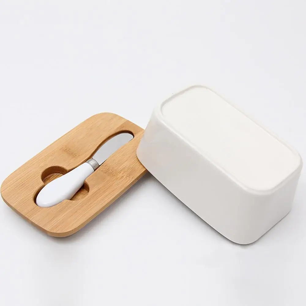 Фарфоровая тарелка для масла с крышкой ножа французского Изолированная коробка